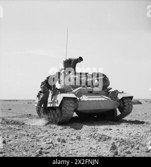 Im März 1942 steigt eine Valentine-Panzerbesatzung der britischen Armee in Nordafrika in ihr Fahrzeug ein, um die Panzeroperationen während des nordafrikanischen Feldzugs zu veranschaulichen. Stockfoto