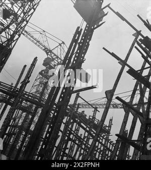Eine Fotografie von Cecil Beaton aus dem Jahr 1943, die die großen Schäfte und Kräne der Tyneside-Werften erfasst und den vorläufigen Bauabschnitt eines Schiffes mit sichtbaren Rippen zeigt. Stockfoto