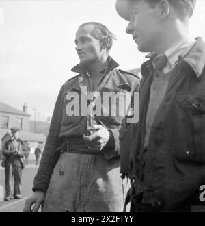 Zwei Schweißer, darunter ein ehemaliger Offizier, werden 1943 auf Tyne Shipyards gesehen, andere Arbeiter und Industriebauten im Hintergrund. Stockfoto