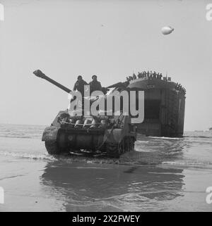 Ein Sherman Firefly der 22. Panzerbrigade, 7. Panzerdivision, kommt am 7. Juni 1944 während des Normandie-Feldzugs von einem Landungspanzer in der Goldzone an Land. Stockfoto
