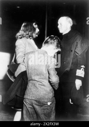 BRITISCHE EVAKUIERTE AUS DEN VEREINIGTEN STAATEN ÜBERQUEREN DEN ATLANTIK IN EINEM BEGLEITSCHIFF. APRIL 1944, AN BORD DER HMS EMPRESS WÄHREND IHRER HEIMFAHRT ZU EINEM BRITISCHEN HAFEN MIT EINER GRUPPE VON MEHR ALS 50 FRAUEN UND KINDERN, DIE AUS AMERIKA EVAKUIERT WURDEN. - Davina, 15, und Simon Bowes-Lyon, 12, Nichte und Neffe der Königin, verabschieden sich vom Kommandanten der KAISERIN, Captain H A Traill, RN Royal Navy, HMS Empress, Escort Carrier, (1942), Traill, Henry Austin, Bowes-Lyon, Davina Katherine, Bowes-Lyon, Simon Alexander Stockfoto