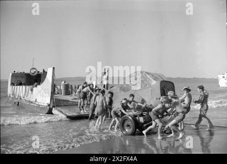 RAF-Mitarbeiter entluden den zwischen 1941 und 1945 den Rumpf eines Vultee Stinson Wächters von einem Landungsschiff, das mechanisiert wurde, auf einen Strand an der Arakan-Küste Burmas. Stockfoto