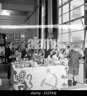 AUSSTELLUNG VON SPIELZEUG FÜR RUSSLAND, ST MARTIN's SCHOOL OF ART, LONDON, 1942 - Jungen der Acton County School helfen, Geschenke von Spielzeug und Spielen zu arrangieren, die für Kinder in Russland bestimmt sind. Unter ihnen hält Peter Val (dritter von links) ein Modell eines aus Streichhölzern gefertigten Schlachtschiffes. Viele der ausgestellten Spielzeuge waren von Kindern Stockfoto