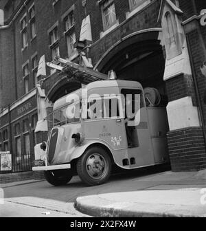 DER WIEDERAUFBAU EINES „VORFALLS“: ZIVILSCHUTZ-AUSBILDUNG IN FULHAM, LONDON, 1942 – Ein Feuerwehrauto verlässt die Fulham Fire Station auf dem Weg zum Vorfall, anderswo im Stadtteil. Die Feuerwehrmänner setzen ihre Helme und Gasmasken auf. Die Fulham Fire Station befindet sich in der Fulham Road 685 Stockfoto