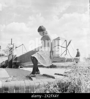 BRITISCHE KANÄLE IM KRIEG: TRANSPORT IN GROSSBRITANNIEN, 1944: Valerie Gribbis, Tochter eines Kanalschiffers, öffnet die oberen Tore einer Schleuse, irgendwo entlang des Grand Union Canal Stockfoto