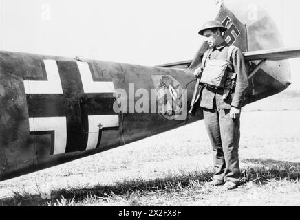 Ein Mitglied der Home Guard steht am hinteren Rumpf einer Messerschmitt Bf 109E-4 von 6./JG 51, die am 24. August 1940 in East Langdon, Kent, abstürzte; der Pilot wurde unverletzt gefangen genommen. Stockfoto