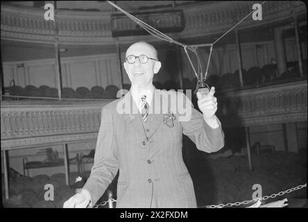 Der Dirigent Charlie Shadwell lacht, während er sich auf die Leitung des BBC Variety Orchestra während der 1945 Aufnahme der Radiokomödie IT's That man Again in einem Londoner Theatersaal vorbereitete. Stockfoto