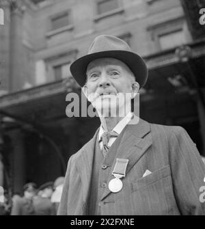 HARRY HARGREAVES GEHT NACH BUCKINGHAM PALACE: VON YORKSHIRE NACH LONDON, UM SEINE BRITISH EMPIRE-MEDAILLE 1943 zu SAMMELN – Ein auffälliges Kopf-und-Schultern-Porträt von Harry Hargreaves, BEM, der seine British Empire Medal vor dem Buckingham Palace trägt Stockfoto