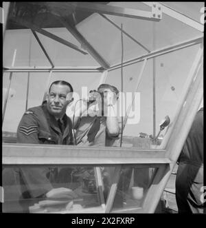 Auf dem Prestwick Airport in Ayrshire, Schottland, 1944 beobachten Flughafenlotsen, darunter ein RAF Sergeant, Flugzeugstarte vom Kontrollturm aus mit einem Fernglas zur Überwachung. Stockfoto