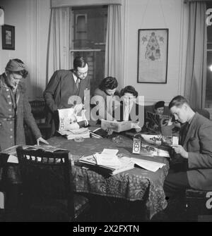 BRITONS LERNEN TÜRKISCH: ERWACHSENENBILDUNG IN LONDON, 1943 - britische Associate Mitglieder der Londra Turk Halkevi lesen Kopien der türkischen Zeitschrift Cephe, um ihnen beim Studium der Sprache zu helfen. Von links nach rechts sind sie: Miss Blundell, Mr. J P Hardy, Miss Nora Bagguley, Miss K Griffin und Mr. Alistair Goldsworthy. Die meisten lernen Türkisch aus geschäftlichen Gründen. Hinter ihnen an der Mauer befindet sich ein altes Kaiserdekret, geschrieben in altrarabischer Schrift. Sie wurde den Halkevi von Sultan Mahmut überreicht Stockfoto