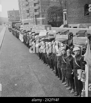 DER WIEDERAUFBAU EINES "VORFALLS": ZIVILSCHUTZ-AUSBILDUNG IN FULHAM, LONDON, 1942 - Mitglieder verschiedener Zivilschutzdienste, darunter Krankenwagen, Rettungs- und Bahren-Parteien, Zivilschutz-Aufseher und Pflegepersonal, stellen sich am Ende einer groß angelegten Zivilschutz-Ausbildung in Fulham an ihre Fahrzeuge. An dieser Übung waren zwölf Fahrzeuge und fünfzig Mitarbeiter, ausgenommen die Feuerwehr, beteiligt. Der Vorfallsoffizier, der einen blauen Helm trägt, steht neben seiner blauen Lampe und Flagge im Vordergrund. Dieses Foto wurde in der Conan Street aufgenommen, jetzt West Cromwell Road, Klo Stockfoto