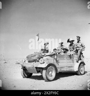 Italienische Gefangene werden am 20. Juni 1942 von Männern der 50. Division der britischen Armee in einem deutschen Kubelwagen in Nordafrika begleitet. Stockfoto
