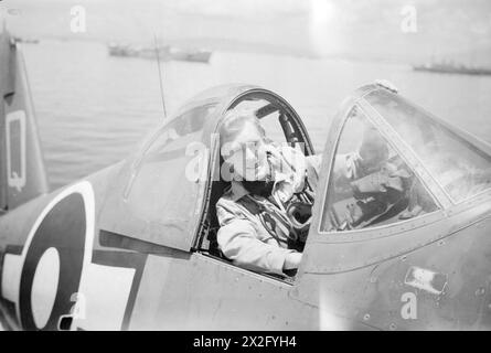 WIR SERVIEREN MIT DEN ERHABENEN. APRIL 1945, AN BORD DES BRITISCHEN FLUGZEUGTRÄGERS HMS ILLUSTROUS, DER IN OSTGEWÄSSERN EINGESETZT WIRD. - Sub Lieut (A) G S Lachs von Egge, Kampfflugzeuge von HMS ILLUSTROUS Stockfoto