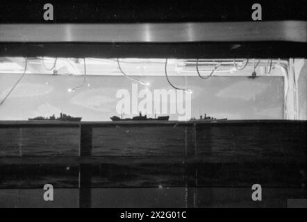 ENTWÄSSERUNG DES ROYAL NAVY-ZUGES AUF DEM MODERNEN SCHULSCHIFF. SEPTEMBER 1941 AN BORD DES ZERSTÖRER-DEPOT-SCHIFFES HMS TYNE. DIE DESTROYERMEN SIND AUSGEBILDET IN GESCHÜTZE, TORPEDOFEUER, U-BOOT-ABWEHR, SEEMANNSCHAFT UND SIGNALGEBUNG. ES WERDEN SCHIFFSMODELLE VERWENDET UND DIE BELEUCHTUNG IST SO ANGEORDNET, DASS SIE DIE EFFEKTE VON SCHEINWERFERN, STERNMUSCHELN UND GESCHÜTZBLITZEN ERZEUGT. - Ein Torpedoangriff, der von hinten auf der Brücke im Schützenraum gesehen wird Stockfoto