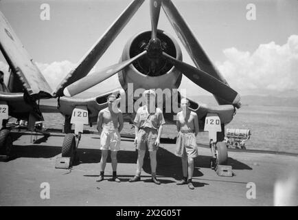 WIR SERVIEREN MIT DEN ERHABENEN. APRIL 1945, AN BORD DES BRITISCHEN FLUGZEUGTRÄGERS HMS ILLUSTROUS, DER IN OSTGEWÄSSERN EINGESETZT WIRD. - Lieut (A) B D Quigg, RNZNVR, Christchurch, Neuseeland, und Wartungsteam. Von links nach rechts: AMA Denis Cahill, Torquay; AME Arthur Baker, Hull Stockfoto