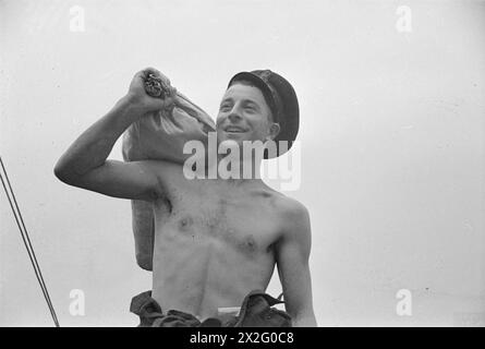 BEI DER AUSBILDUNGSEINRICHTUNG DER HANDELSMARINE HMS GORDON. JUNI 1941, HMS GORDON, GRAVESEND. DIESE MÄNNER VERPFLICHTETEN SICH FÜR DEN DIENST BEI DER ROYAL NAVY UND WURDEN GEBETEN, SICH FREIWILLIG FÜR DEN HANDELSDIENST ZU MELDEN. - Eine Art von wäre Merchant Sailor. Obwohl er nur zwei Tage in der Marine war, freut er sich schon auf das Leben auf See Stockfoto