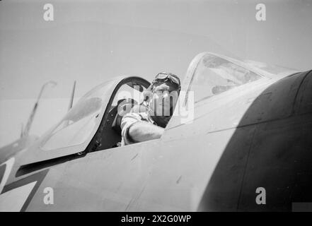 WIR SERVIEREN MIT DEN ERHABENEN. APRIL 1945, AN BORD DES BRITISCHEN FLUGZEUGTRÄGERS HMS ILLUSTROUS, DER IN OSTGEWÄSSERN EINGESETZT WIRD. - Sub Lieut (A) M Barbour, RNZNVR, aus Wellington, Neuseeland, Jagdpilot mit den ILLUSTREN Stockfoto