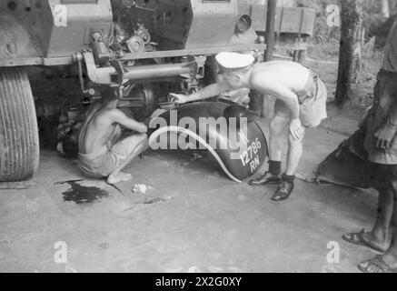 MIT DER FLOTTENLUFTWAFFE IM OSTEN. ROYAL MARINEFLUGSTATION KATAKURUNDA, CEYLON. TÄTIGKEITEN DES FLOTTENFLUGWAFFENBODENPERSONALS IN DEN TROPEN. - Viele der jungen Männer von Ceylon haben sich freiwillig gemeldet, in der großen Marine-Landeinrichtung zu dienen. Ein Petty Officer, der einen Ceyloneser Motormechaniker anweist, der barfuß arbeitet Stockfoto