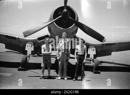 WIR SERVIEREN MIT DEN ERHABENEN. APRIL 1945, AN BORD DES BRITISCHEN FLUGZEUGTRÄGERS HMS ILLUSTROUS, DER IN OSTGEWÄSSERN EINGESETZT WIRD. - Sub Lieut (A) J A O Shaw, RNVR, London und Wartungsteam. Von links nach rechts: AME Edward Gaffney, Bury; AMA Iveion L Pegler, Tetbury Stockfoto