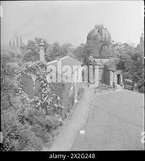 THE ROYAL OBSERVATORY: DAS TÄGLICHE LEBEN AM ROYAL OBSERVATORY, GREENWICH, LONDON, ENGLAND, VEREINIGTES KÖNIGREICH 1945 - Eine Ansicht der Bombenschäden an verschiedenen Gebäuden am Royal Observatory in Greenwich, die vom Hauptgebäude aus nach Norden geschaut wurden. In der Mitte befindet sich der Altazimuth Pavillon und im Hintergrund das große Äquatorialgebäude (auch bekannt als Zwiebeldom). Beide Gebäude wurden im Herbst 1940 durch eine Bombe beschädigt, aber auch der Zwiebeldom wurde im August 1944 durch eine Bombe beschädigt Stockfoto