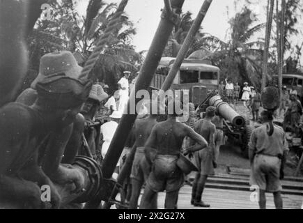 MARINES VERSTÄRKEN GEHEIME TROPISCHE ANKERPLÄTZE. 1944, ADDU ATOLL, MALEDIVEN. DIE DREIECKIGE GRUPPE VON KORALLENBUCHTEN AUF DEN MALEDIVEN, DIE TROTZ DER BENACHTEILIGUNGEN DURCH KRANKHEIT UND DSCHUNGEL HEIMLICH ALS ANKERPLATZ FÜR SCHIFFE BEFESTIGT WURDEN, DIE DIE WEITEN GEBIETE DES INDISCHEN OZEANS ÜBERQUERTEN, DIE IM SEPTEMBER 1941 VON DEN ROYAL MARINES DORTHIN GESCHICKT WURDEN. - Das Barrel einer der großen Küstenverteidigungswaffen, die auf dem Anblick ankommen Stockfoto