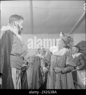 LERNEN DURCH SCHAUSPIELEREI: AUSBILDUNG DURCH THEATER FÜR EVAKUIERTE AN Einer „CAMP SCHOOL“, MARCHANT's HILL, HINDHEAD, SURREY, 1943 – Mavis Clode (rechts) und John Chandler (beide 13 Jahre alt) auf der Bühne während der Aufführung ihres Stücks über elisabethanisches England an der Marchant's Hill School. Mavis spielt die Rolle der Königin Elisabeth I. und John ist der Herzog von Cordoba, der Botschafter von König Philipp von Spanien. Hinter ihnen sind zwei weitere Kinder in ihren elisabethanischen Kostümen zu sehen Stockfoto