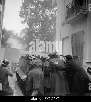 TUNIS WURDE VON DER 1. ARMEE GEFANGEN GENOMMEN - mit einem bren-Träger als Deckung, alliierte Truppen in Aktion während der Straßenkämpfe Stockfoto