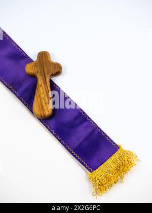 Lila-violette Priester gestohlen mit einem Kreuz, weißem Hintergrund Stockfoto