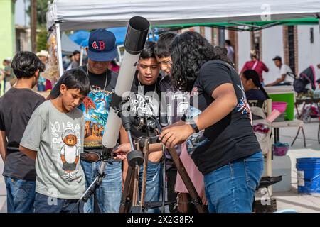 Kinder versammeln sich um das Teleskop, um sich auf die Sonnenfinsternis 2024 in Mapimi, Mexiko, vorzubereiten Stockfoto