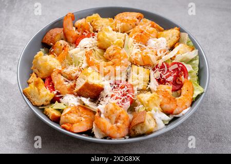 Shrimps Caesar Salat in einer Schüssel mit Parmesankäse, Salat, Dressing und Croutons Stockfoto