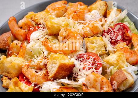 Shrimps Caesar Salat in einer Schüssel mit Parmesankäse, Salat, Dressing und Croutons Stockfoto