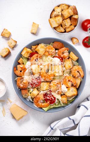 Shrimps Caesar Salat in einer Schüssel mit Parmesankäse, Salat, Dressing und Croutons Stockfoto