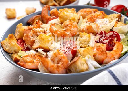 Shrimps Caesar Salat in einer Schüssel mit Parmesankäse, Salat, Dressing und Croutons Stockfoto
