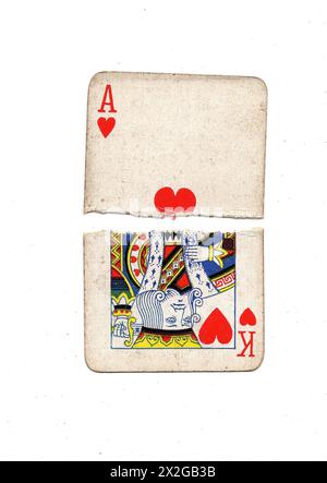 Zerrissene Hälften alter Spielkarten, die einen König und ein Ass der Herzen auf weißem Hintergrund zeigen. Stockfoto