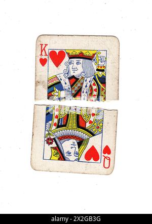 Zerrissene Hälften von Vintage-Spielkarten, die einen König und eine Königin der Herzen auf weißem Hintergrund zeigen. Stockfoto