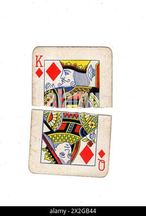 Zerrissene Hälften von Vintage-Spielkarten, die eine Königin und einen König von Diamanten auf weißem Hintergrund zeigen. Stockfoto