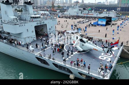 (240422) -- QINGDAO, 22. April 2024 (Xinhua) -- dieses Drohnenfoto zeigt Menschen, die das Versorgungsschiff Kekexilihu (Vorderseite) am Pier 3 im Qingdao Hafen von Qingdao, ostchinesischer Provinz Shandong, am 21. April 2024 besuchen. Die chinesische Volksbefreiungsarmee Navy hält um den 23. April in mehreren Küstenstädten, darunter Qingdao, Open Day Events ab, um den 75. Jahrestag ihrer Gründung zu feiern. Vom 20. Bis 24. April kann die Öffentlichkeit in Qingdao die Raketenzerstörer Guiyang, Shijiazhuang und Kaifeng, die Raketenfregatte Handan, das Versorgungsschiff Kekexilihu und das U-Boot Hongzehu bei t besichtigen Stockfoto