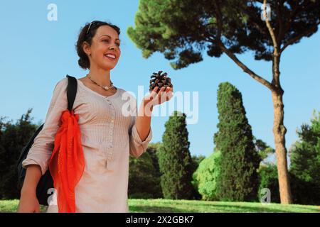 Schöne junge Frau in weißer Bluse, die großen Kegel hält und geht Stockfoto