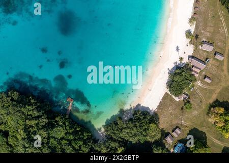 Blick auf den Sandstrand und die grüne Küste in der Nähe des türkisfarbenen Meeres. Touristische Siedlung. Sanma, Vanuatu Stockfoto