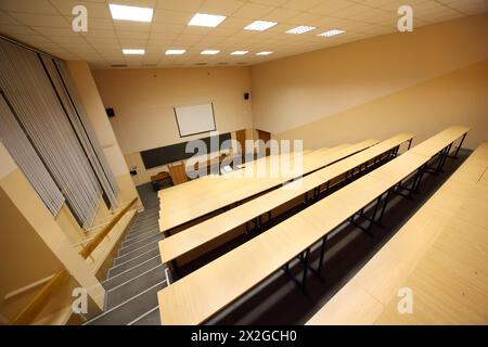 Klassenzimmer, Universitätsvorlesungssaal, große Tafel, Holzschreibtische und -Bänke Stockfoto