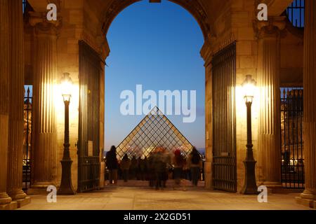 PARIS - 1. JANUAR: Touristen im Louvre schauen sich die Louvre-Pyramide an, 1. Januar 2010, Paris, Frankreich. Die Glaspyramide des Louvre dient in Napoleo Stockfoto