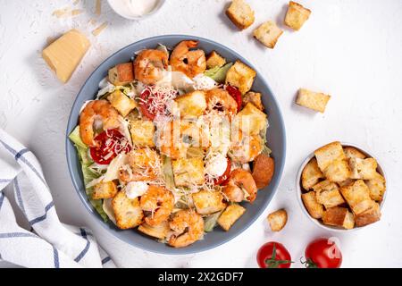 Shrimps Caesar Salat in einer Schüssel mit Parmesankäse, Salat, Dressing und Croutons Stockfoto