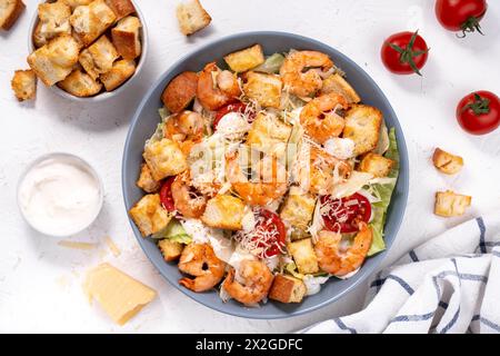 Shrimps Caesar Salat in einer Schüssel mit Parmesankäse, Salat, Dressing und Croutons Stockfoto
