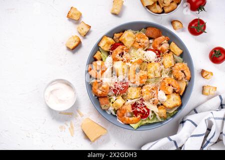 Shrimps Caesar Salat in einer Schüssel mit Parmesankäse, Salat, Dressing und Croutons Stockfoto