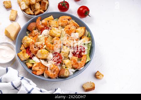 Shrimps Caesar Salat in einer Schüssel mit Parmesankäse, Salat, Dressing und Croutons Stockfoto