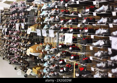 Große Sammlung verschiedener Sportschuhe im Sportgeschäft; viele Reihen Sneakers Stockfoto