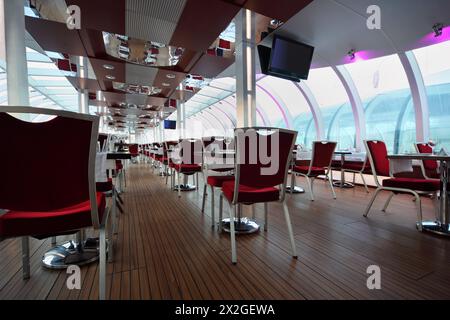 Leichtes Restaurant an Bord des Schiffes, Reihen von Tischen und roten Stühlen Stockfoto