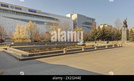 Craiova, Rumänien - 16. März 2024: Reiterstatue von Michael dem Mutigen vor dem leeren Brunnen und dem Mercur Center am sonnigen Frühlingstag. Stockfoto