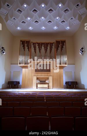 Massive hölzerne Pfeifenorgel mit Bedienfeld in leerem Konzertsaal Stockfoto