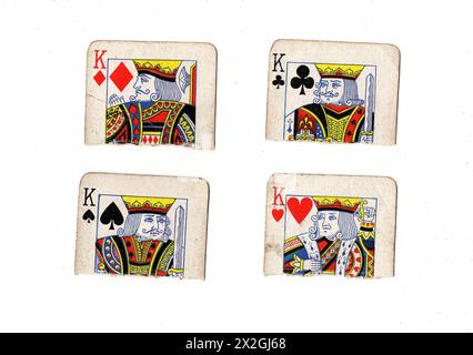 Zerrissene Hälften von Vintage-Spielkarten, die einen König in allen vier Anzügen auf weißem Hintergrund zeigen. Stockfoto